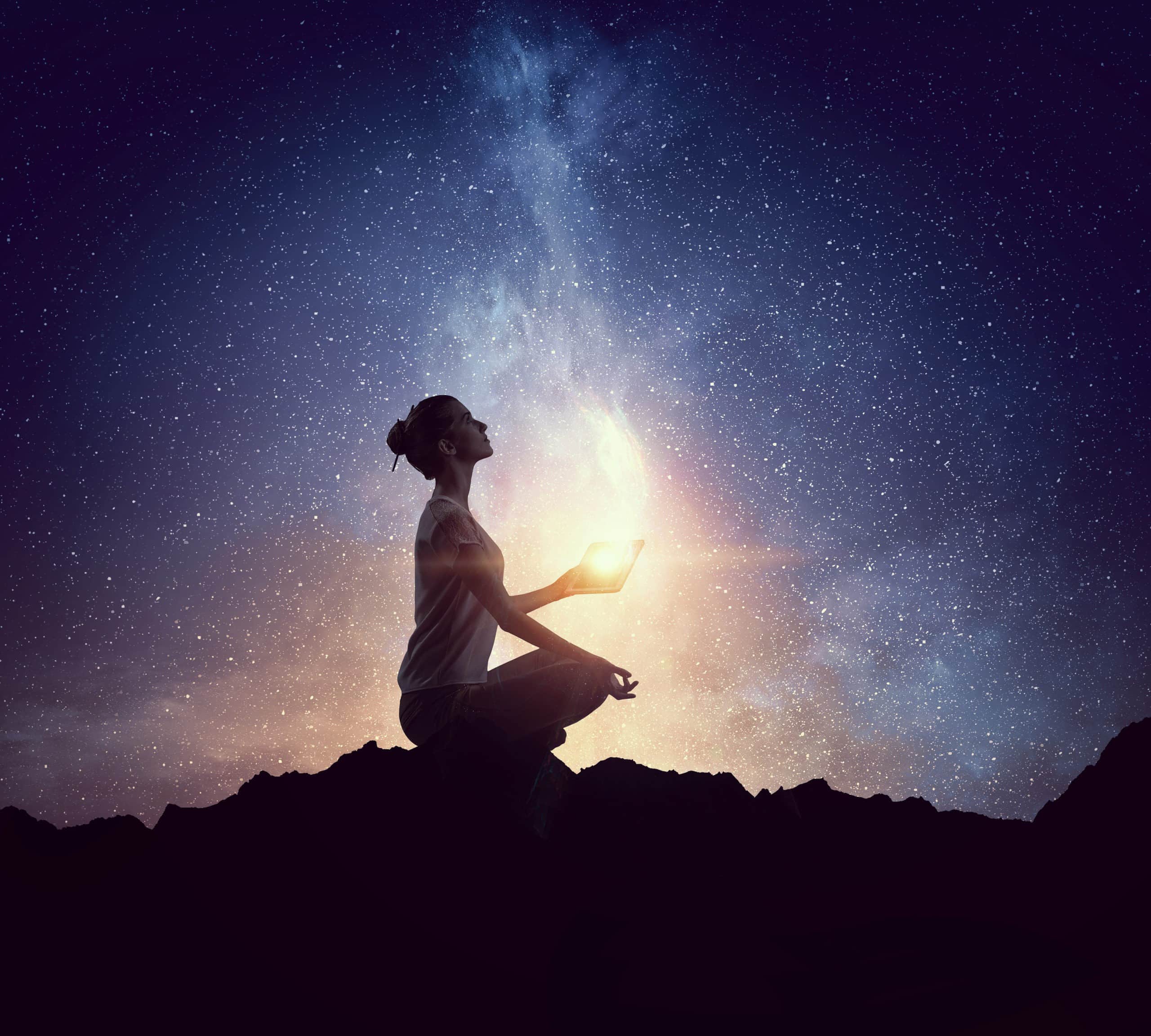 woman meditating under the night sky